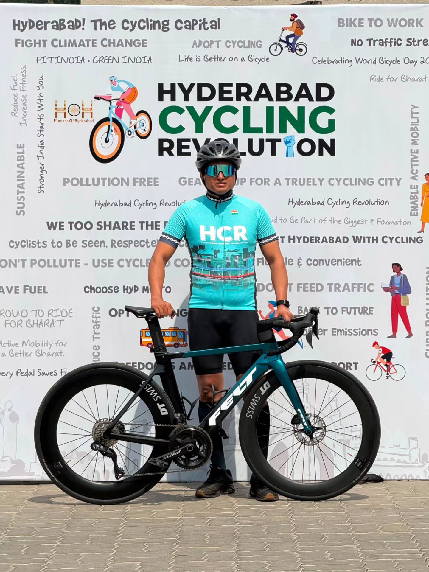 Ravi with his bicycle before a Hyderabad Cycling Revolution campaign banner