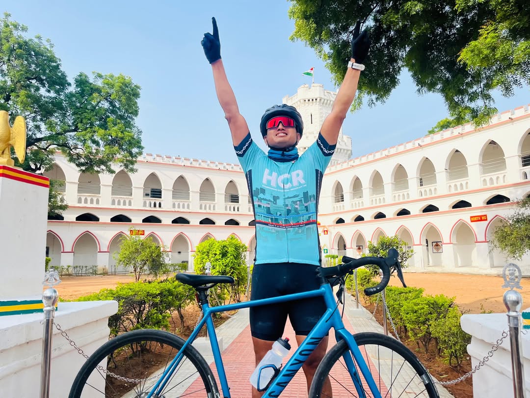 Ravi raising both arms in celebration at the end of a ride